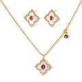 Gold-plated quatrefoil necklace and earring set with white enamel, pink cubic zirconia centers, and crystal borders