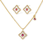 Gold-plated quatrefoil necklace and earring set with white enamel, pink cubic zirconia centers, and crystal borders