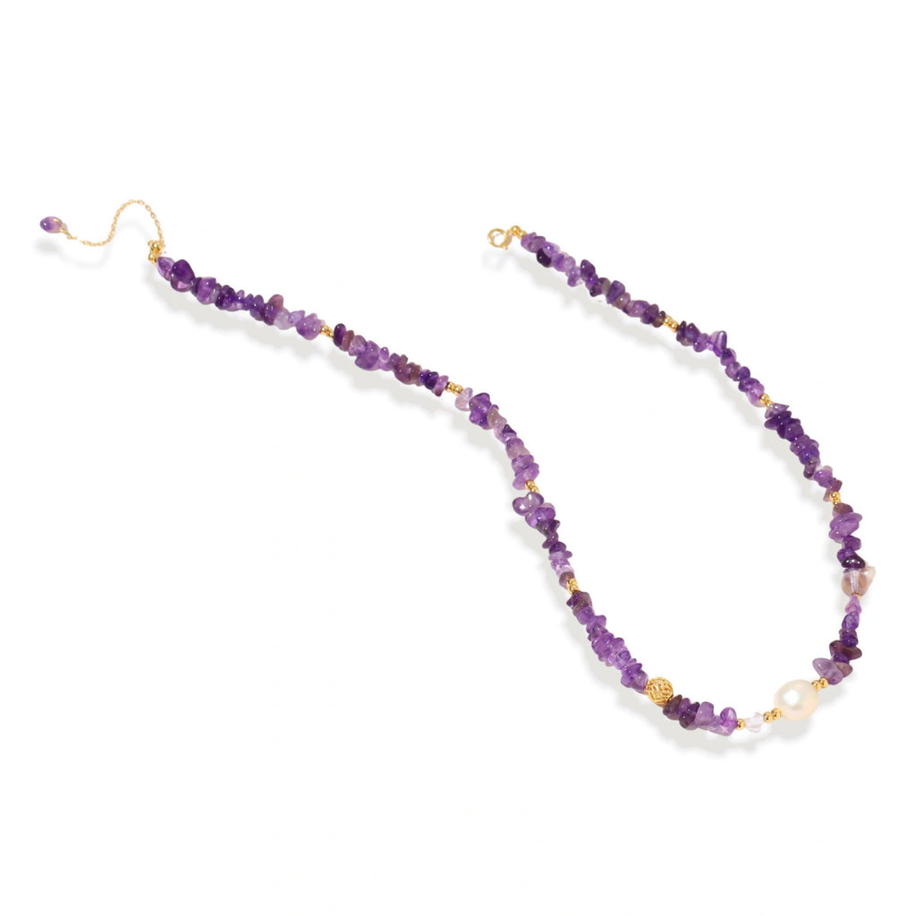 Beaded necklace with purple amethyst chips, freshwater pearls, and gold accents on white background.