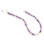 Beaded necklace with purple amethyst chips, freshwater pearls, and gold accents on white background.