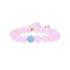 Stretchy beaded bracelet with pink rose quartz, blue aquamarine, carved floral pendant, and pearl tassel clasp.