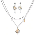 Delicate eco-brass jewelry set featuring gold star and silver moon crescents with clear zirconia crystal drops on cream background