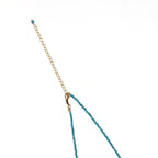 Delicate gold vermeil necklace with teal apatite beads and freshwater pearl on white background.
