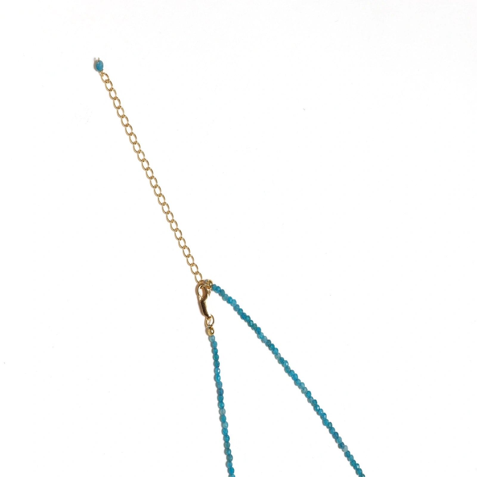 Delicate gold vermeil necklace with teal apatite beads and freshwater pearl on white background.