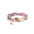Stretchable bracelet with pastel gemstone beads, freshwater pearls, gold centerpiece and butterfly charm on cream background