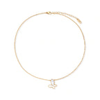 Gold-plated butterfly pendant with iridescent mother of pearl inlay on delicate chain against cream background.