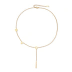 Gold Y-shaped necklace with L-O-V-E letter charms and vertical bar pendant on delicate chain against cream background
