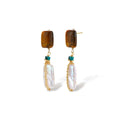 Gold-plated drop earrings with amber stones, teal beads, and wire-wrapped baroque pearls on cream background.