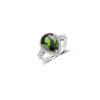White gold plated jewelry set with green teardrop gemstones and cubic zirconia halos on cream background.