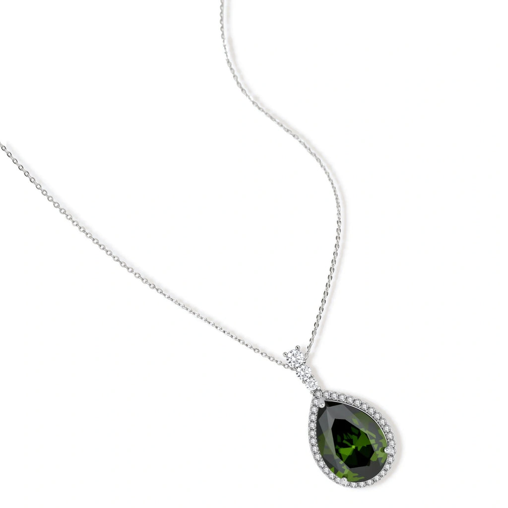White gold plated jewelry set with green teardrop gemstones and cubic zirconia halos on cream background.