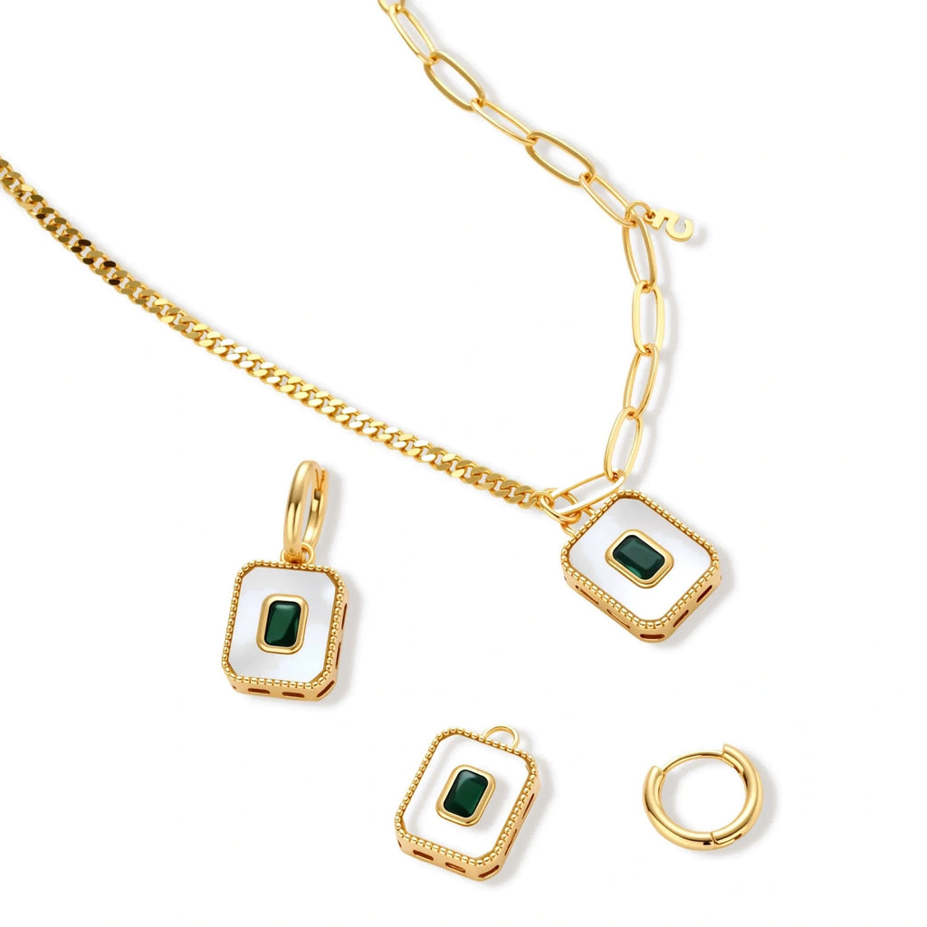 Gold-plated jewelry set with white enamel square pendants and emerald CZ stones on cream background.