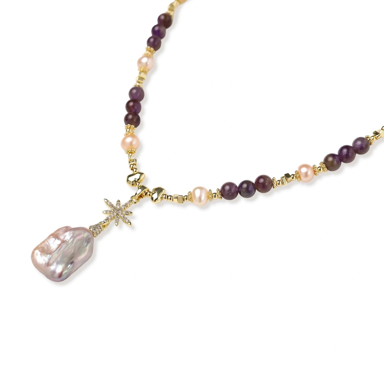 Gold necklace with iridescent baroque pearl pendant, purple amethyst beads, and crystal star charm on cream background
